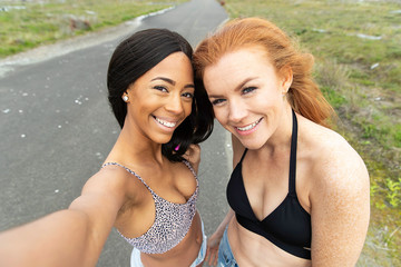 two smiling young women taking a selfie together