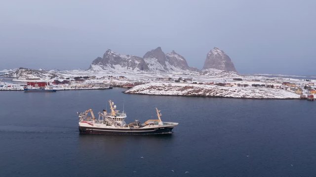 Fishing vessel in winter, Tr&aelig;na archipelago, Nordland, Northern Norway, aerial drone shot