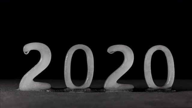 Time lapse of 2020 text written with ice characters melting. Conceptual video of the decade start and the global warming concerns.