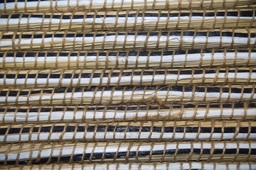 Background of strips of seaweed hyacinth white and black, fastened with twine grid pattern....