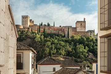 Cityscape of the famous Alhambra’s palace in Granada, Spain. Low angle view of the majestic Muslim palace and fortress