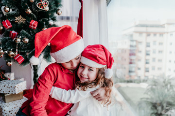 brother and sister at home playing and having fun. Family time, love and christmas concept