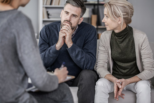 Wife and husband during marriage therapy with counselor