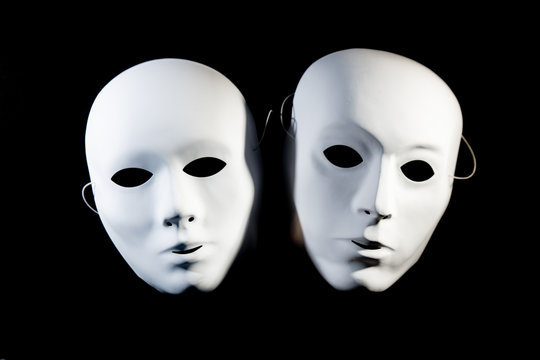 white masks of man and woman on a black background