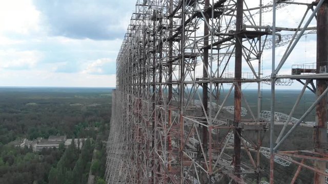 Ascending aerial view of massive Duga radar antenna near Chernobyl. Soviet missile defense system in radioactive exclusion zone of atomic disaster site in Ukraine. 