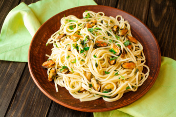 Seafood pasta with clams golden spaghetti alle Vongole on wooden background