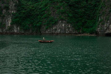 Fototapeta na wymiar a single boat making its way through the waters of Ha Long Bay