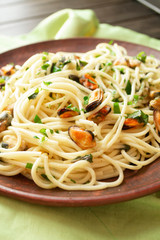 Spaghetti with mussels meat and herbs, vertical image