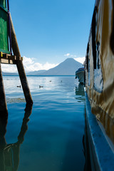 Volcano framed by pier and boat on a beautiful day.