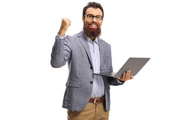 Happy bearded man gesturing win and holding a laptop computer