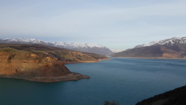 Picturesque landscape and lake, Charvak reservoir, winter snow mountains at the sunset 