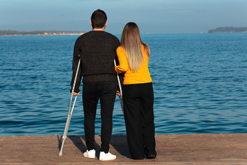 young man and young woman walking with crutches
