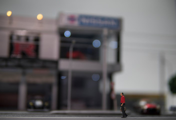 Obraz premium Selective focus of doll figure adult man walk along pedestrian walkway with blurred background.