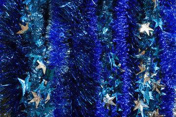 Abstract background of festive blue tinsel with silver stars.