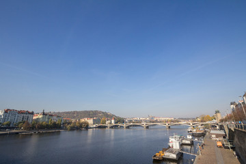 Fototapeta na wymiar Panorama of Prague, Czech Republic, seen from the Vltava river, with a focus on Palackevo Most bridge and the riverbnaks. Prague is the main touristic destination of Central Europe
