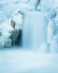 water flowing in winter with snow and ice. Canadian river waterfall.