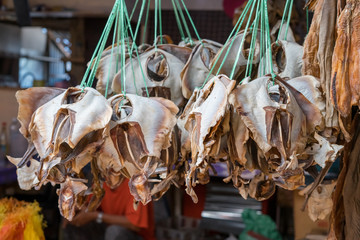 Dried fish tied into several bundles for sale, hanging from above, in a local fish market in Semporna, Sabah.