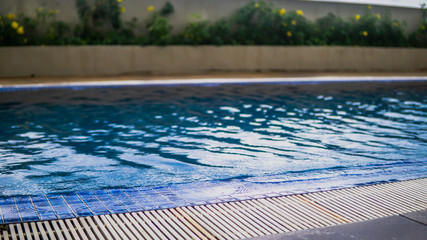 An empty swimming pool with sunlight reflected on the water.
