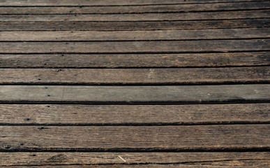 Worn wood deck at the marina, dark brown. Horizontal wood lines for background. Abstract. wood grain