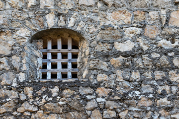 Fototapeta na wymiar iron bars in medieval castle window and stone old wall of a medieval An Felipe castle construction in Guatemala. Background.