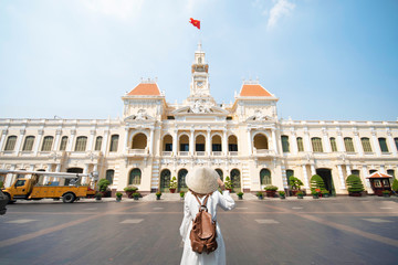 Woman tourist is traveling and sightseeing at Hochiminh people's committee hall landmark of Saigon,...