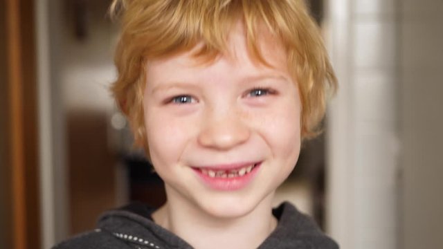 Boy with milk tooth gap laughs wonderfully at the camera