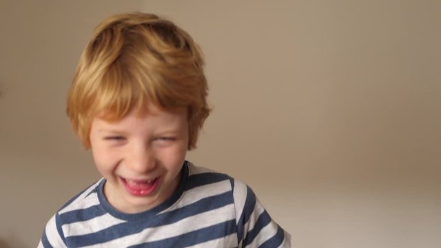 Funny boy with milk tooth gap grimaces in front of the camera
