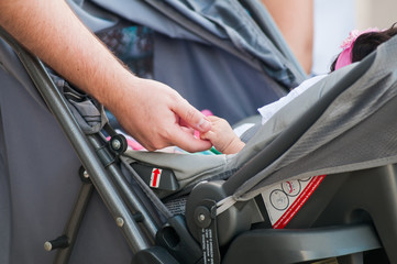 man taking the baby's hand inside the stroller