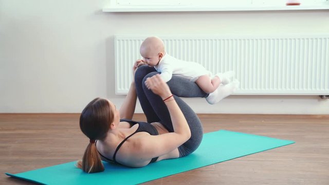 Mom does fitness with the baby for the muscles on the arms and legs.