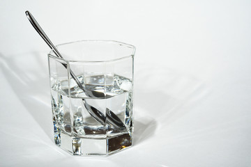 steel spoon in a glass with clear water