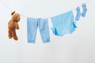 baby clothes hanging on  rope on white background