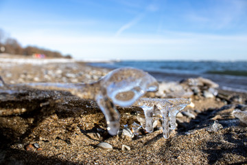 Ice shapes on the beach from rocks and pebbles in the winter
