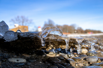 Ice shapes on the beach from rocks and pebbles in the winter