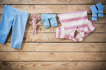 baby clothes hanging on  rope on wooden background