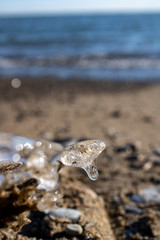 Ice shapes on the beach from rocks and pebbles in the winter