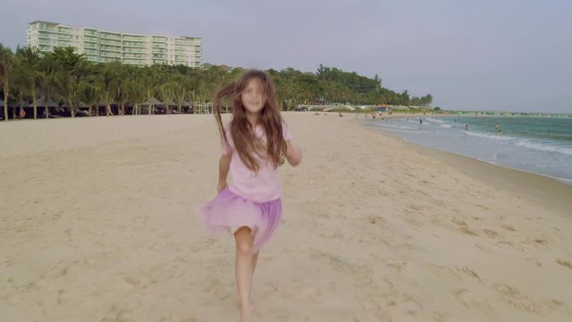Cute Little Girl Enjoying and Having Fun on Sand Beach in Slow Motion.