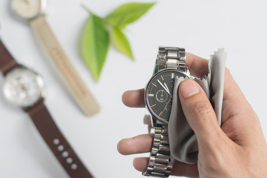 Close up cleaning modern watch with microfiber cloth and Cleaner cream concept.Cleaning modern watch by Cleaner cream.Cleaning stainless steel by Cleaner cream,Cleaning leather by Cleaner cream,