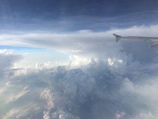 Naklejka na ściany i meble an aerial view of mushroom shaped clouds from airplane cockpit window, horizontal form