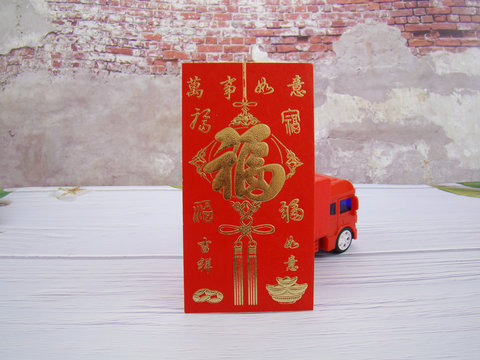 Chinese red packet and red truck on wood grain floor