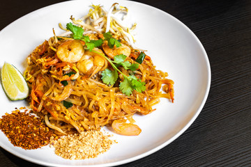 Pad thai or phad thai, is a stir-fried rice noodle traditional dish served as a street food in Thailand. It is a stir-fry dish made with shrimp, chicken, peanuts, bean sprouts. Authentic Thai food.