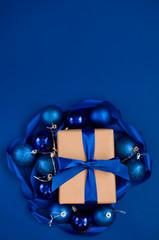 New Year's gift on a blue background, with a beautiful satin ribbon. Christmas. New Year's content.