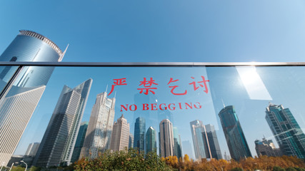 No begging slogan on glasses with Shanghai skyline background, the Chinese text means no begging.