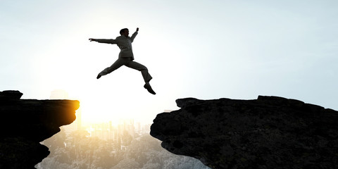 Businessman jump over leap. Mixed media