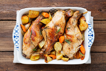 Stewed in white wine with spices rabbit legs with baked vegetables and rosemary.