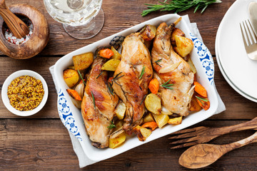 Stewed in white wine with spices rabbit legs with baked vegetables and rosemary.