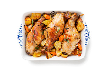 Stewed in white wine with spices rabbit legs with baked vegetables and rosemary. isolated on white background