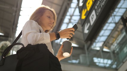 Passenger Traveler Business Woman Wearing Smartwatch In Airport Using Smartphone