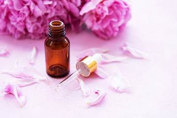 Aromatherapy essentials oils and pink peonies