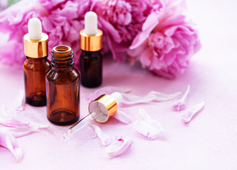 Fototapeta na wymiar Aromatherapy essentials oils and pink peonies