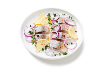 Salted herring with spices, lemon and red  onion rings isolated on white background. Marinated sliced fish. 